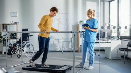 Hospital Physical Therapy Room: Patient with Injury Walking on Treadmill Holding for Parallel Bars,...