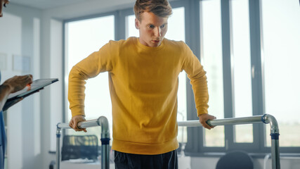 Hospital Physical Therapy: Portrait of Strong Male Patient with Injury Successfully Walks Holding...