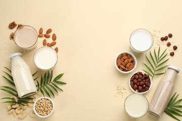 Fototapeta na wymiar Different vegan milks and ingredients on beige background, flat lay. Space for text