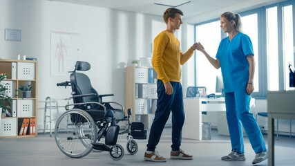 Hospital Physical Therapy: Determined Young Man with Injury Successfully Stands up from Wheelchair...