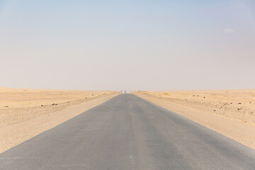 Fototapeta na wymiar long straight empty road surrounded by desert in hadramaut, yemen