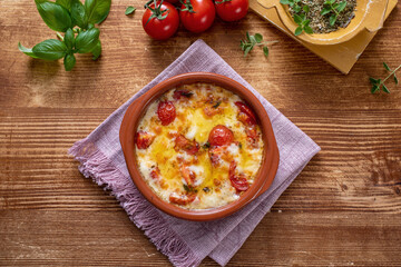 tegame al forno con formaggio fuso e pomodri freschi
