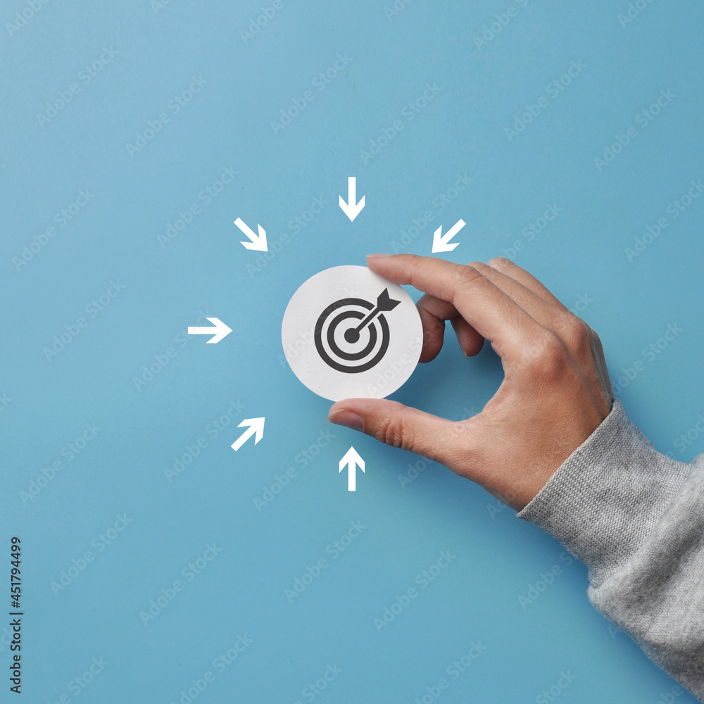 Poster the target icon in the hand and the arrows to it. the symbol of achieving the goal in different ways