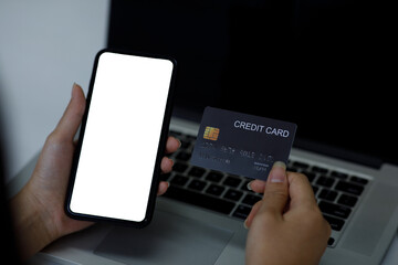 woman holding smart phone and credit card for shopping online.Blank screen monitor for graphic display montage.Digital money transfer, banking and e commerce concept.