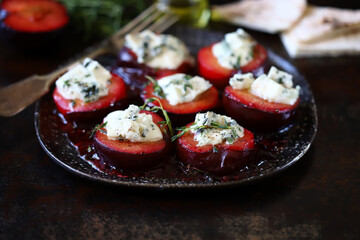 Baked plums with dor blue cheese and thyme. Gourmet recipes with plums. Autumn dishes.