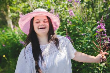 Portrait of trisomy adult outside having fun with flowers
