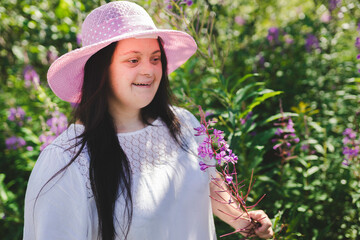 Portrait of trisomy adult outside having fun with flowers