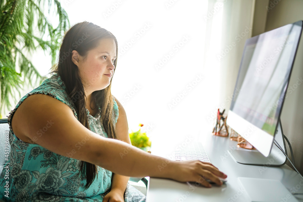 Wall mural Portrait of trisomy 21 adult working on computer