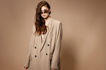 stylish brunette woman in coat on beige background Copy Space