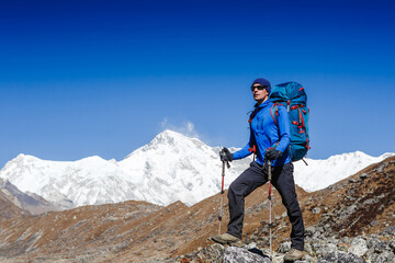 Active hiker hiking, enjoying the view, looking at Himalaya mountains landscape. Travel sport lifestyle concept. Cho Oyu is the world's sixth highest mountain at background