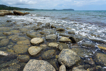 Large stones and white sea foam and waves