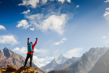 Hiker cheering elated and blissful with arms raised in the sky after hiking. Everest base camp trek