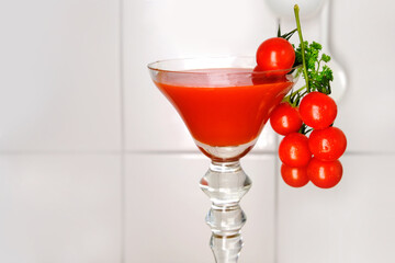 juicy bunch of red small cocktail tomatoes, tomato juice is poured into a glass, healthy food concept, healthy drink, ingredient for making salad, sauce