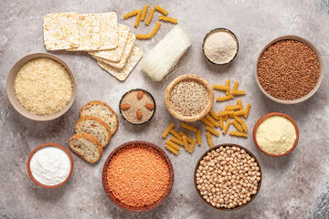 Selection of gluten free food on a rustic background. A variety of grains, flours, pasta, and bread gluten-free. Top view, flat lay. - obrazy, fototapety, plakaty