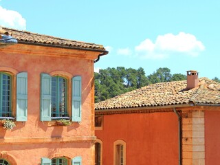 A popular tourist holiday destination, beautiful French village in Provence called Roussillon with its ancient houses and buildings, old ochre-colored roofs and walls, and relaxed summer vibes.