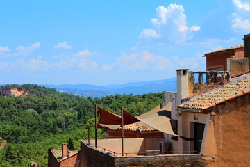 A popular tourist holiday destination, beautiful French village in Provence called Roussillon with its ancient houses and buildings, old ochre-colored roofs and walls, and relaxed summer vibes.