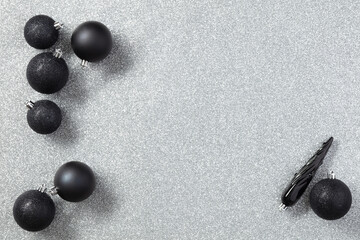 Black Christmas toys or decor on a gray background with copy space