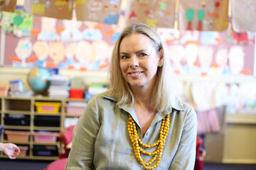 Female teacher sitting in school classroom