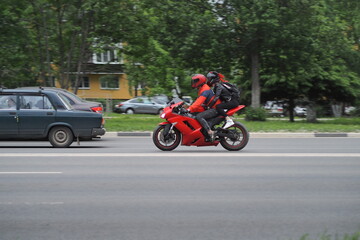 Motorcyclists in special clothes and protective helmets on the goal ride on the city highway. on a red motorcycle. High