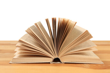 Open book on wooden table against white background. Library material