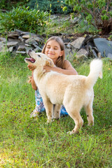 A teenage girl plays with a Labrador puppy in the garden.