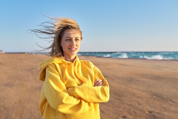 Outdoor portrait of happy woman 45 years old looking at camera with crossed arms