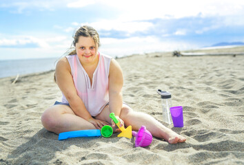 Fototapeta na wymiar Trisomy 21 woman having fun at the beach