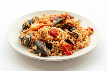 Seafood rice, typical Italian food. Served on a white background.