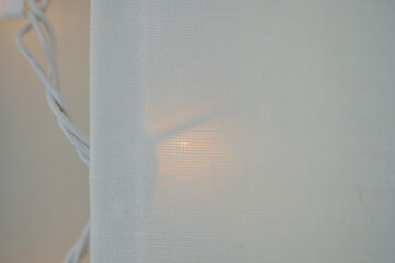 Horizontal image of Soft linen curtains covering soft white  lights inside a home making for a...