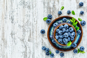 Fresh blueberries background with copy space for your text.Blueberries in a bowl on a wooden table. Blueberry antioxidant organic superfood in a bowl concept for healthy eating and nutrition