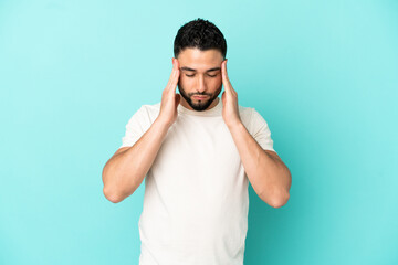 Young arab man isolated on blue background with headache