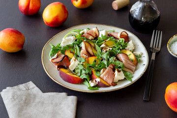 Salad with peaches, arugula, cheese and jamon. Healthy eating.