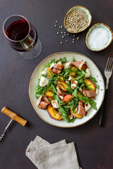 Salad with peaches, arugula, cheese and jamon. Healthy eating.