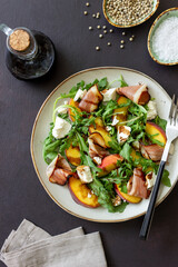 Salad with peaches, arugula, cheese and jamon. Healthy eating.