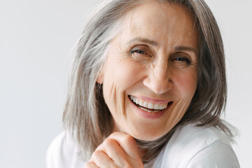 Grey senior woman in t-shirt laughing and looking at camera