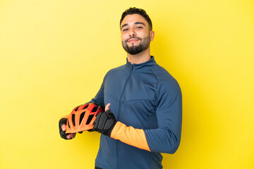 Young cyclist arab man isolated on yellow background proud and self-satisfied