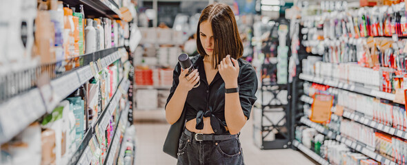 Young woman choosing care cosmetic in a supermarket