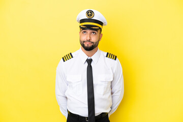 Airplane arab pilot man isolated on yellow background and looking up