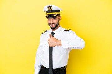 Airplane arab pilot man isolated on yellow background giving a thumbs up gesture