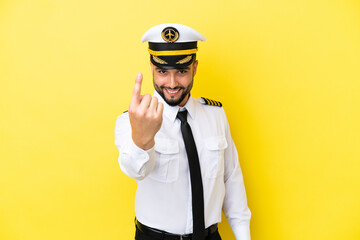 Airplane arab pilot man isolated on yellow background doing coming gesture