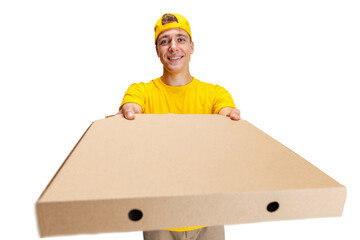 Close up young delivery man in yellow uniform with paper box with pizza isolated on white background. Concept of convenience, speed, comfort, safety, service.