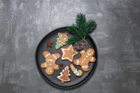 glased traditional Christmas biscuits: ginger bread man, star, christmas tree on a  plate with  anisette starts