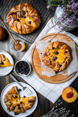 French galette with peaches, blackberries, mascarpone, natural honey and lavender on baking paper.