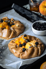 French galette with peaches, blackberries, mascarpone, natural honey and lavender on baking paper.