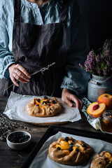 French galette with peaches, blackberries, mascarpone, natural honey and lavender on baking paper.