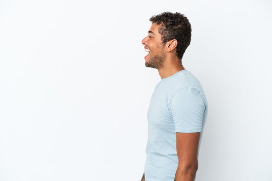 Young handsome Brazilian man isolated on white background laughing in lateral position