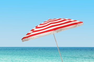 Open big beach umbrella near sea on sunny day