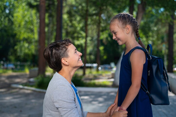 Caucasian woman gathers her first-grader daughter to school