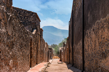 Road through the historic ruins of Pompeii near Naples in Italy with mountains in the background