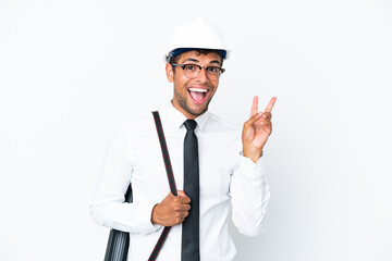 Architect brazilian man with helmet and holding blueprints smiling and showing victory sign